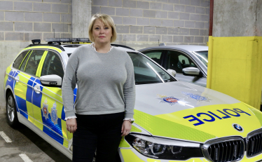 Lisa stands next to a police car