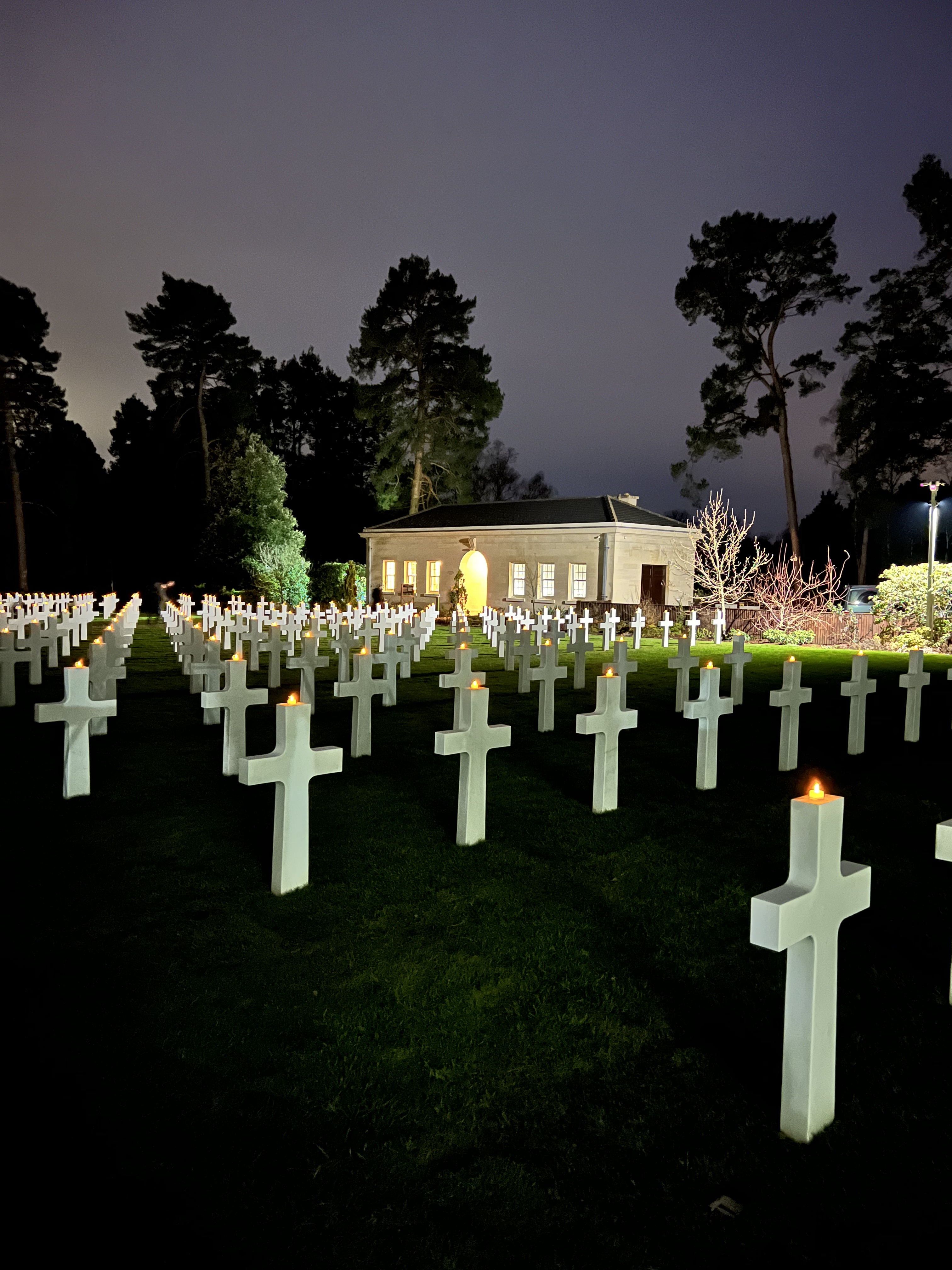 Candles lit on crosses throughout the American Cemetery at Brookwood at dusk 